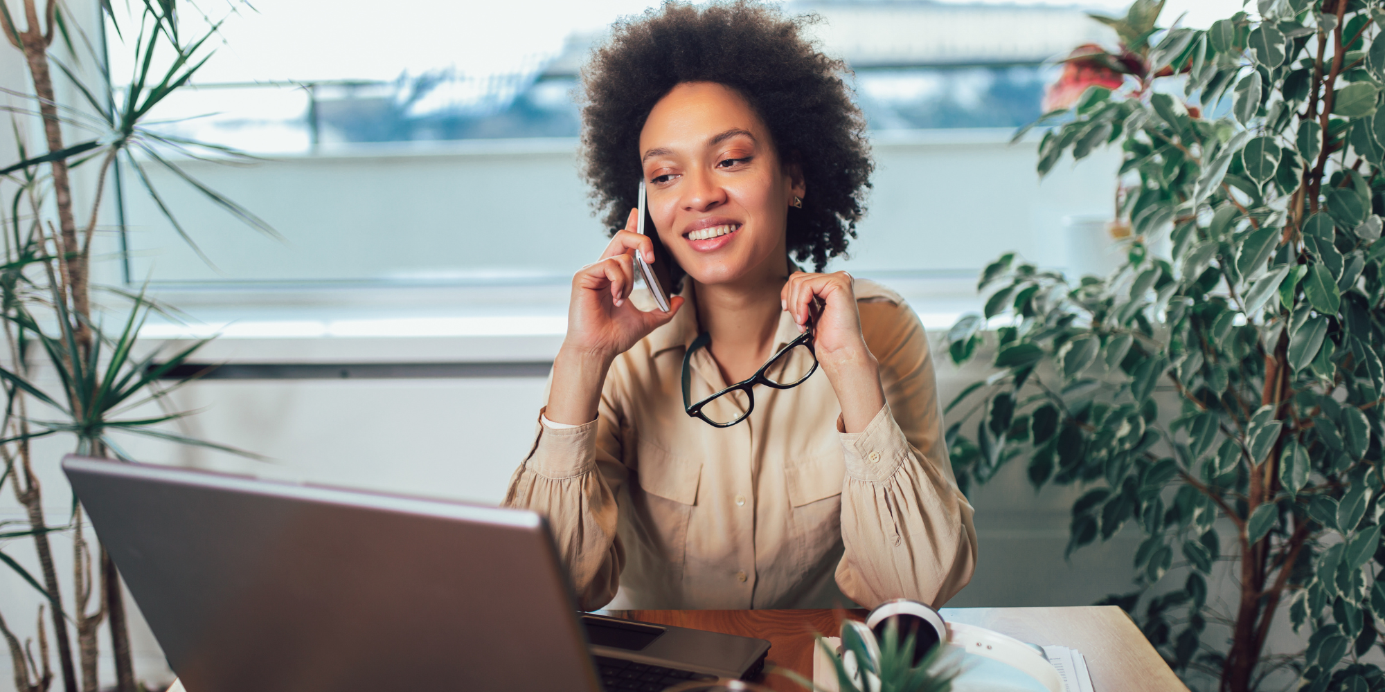 Photo of woman sitting at a desk and talking on the phone.